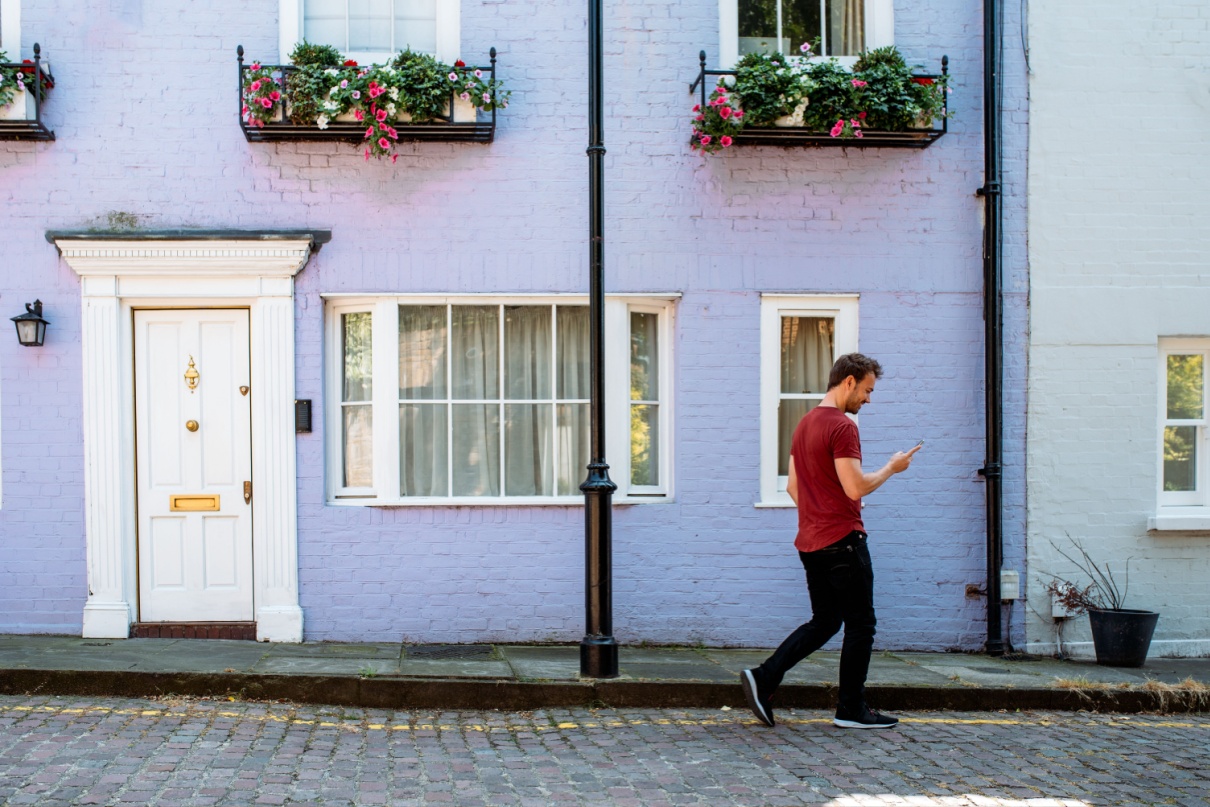 A man walking in front of a terraced house.