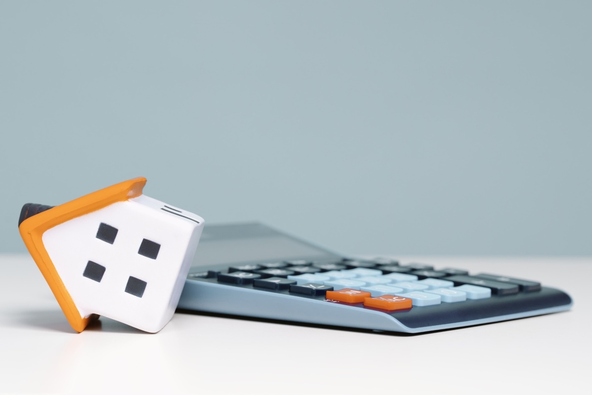 A model of a house next to a calculator.